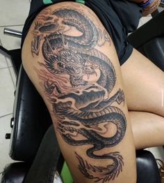 a woman with a dragon tattoo on her thigh