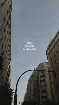 a street light and some tall buildings in the background with an advertisement on it that reads, paris reppirant contemplar