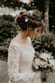 a woman in a wedding dress holding a bouquet and looking down at the ground with her hand on her hip