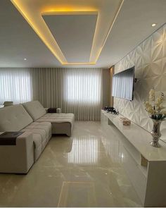 a large living room with white furniture and walls that have geometric designs on them, along with a flat screen tv mounted to the wall