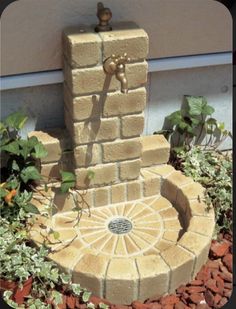 a water fountain in the middle of a flower bed