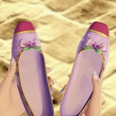 a pair of purple princess shoes being held by someone's hand