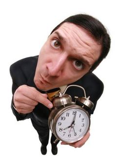 a man holding an alarm clock in front of his face