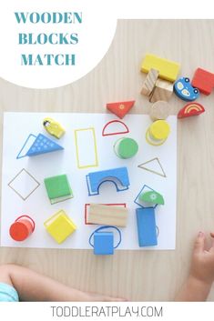 a child playing with wooden blocks and matching shapes on a white sheet that says, wooden blocks match