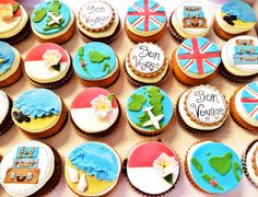 many decorated cupcakes are on display in a box with the words bon voyage written on them