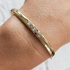 "Our modern 3-stone diamond cuff bracelet features square, emerald and round diamonds set in the middle of a thick, solid gold band. This beautiful bracelet is completely customizable. You can change the diamond shapes, replace diamonds with colored gemstones, change the width, etc. Contact us today with your design idea and for a quote: http://etsy.me/1231fkN Details: - Made at our family-run studio in NYC. - Choose from 14k ,18k (yellow, rose, white Gold) or Platinum. - Solid 14k, 18k yellow, Modern Diamond Bracelet With Bezel Setting, Modern Diamond White Jewelry Channel Set, Modern Channel Set Jewelry As Gift, Modern Channel Set Jewelry For Anniversary, Modern Channel Set Diamond Bracelet For Anniversary, Modern Gold Bracelet With Single Cut Diamonds For Wedding, Modern Cuff Bracelet With Diamond Accents For Formal Events, Diamond Cuff Bracelet For Everyday Luxury, Modern Wedding Diamond Bracelet With Polished Finish