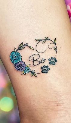 a dog paw and flower tattoo on the ankle