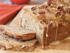 a loaf of bread sitting on top of a wooden cutting board next to sliced bread