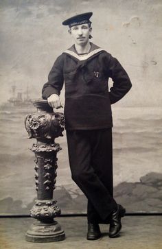 an old photo of a sailor standing next to a fire hydrant