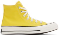 High-top canvas sneakers in yellow. · Rubber cap toe · Lace-up closure · Logo patch and eyelets at inner side · Cushioned OrthoLite® footbed · Rubberized logo patch at heel · Treaded rubber sole · Contrast stitching in white Supplier color: Golden wren/Egret/Black Converse Yellow, Chuck 70 High Top, Sport Shoes Men, Chuck 70, Outdoor Men, Converse Sneakers, Mens Sportswear, Sneaker Collection, Canvas Sneakers