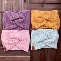 three knitted headbands with bows on them sitting on a wooden surface next to each other