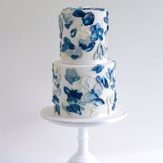 a three tiered cake with blue flowers on it