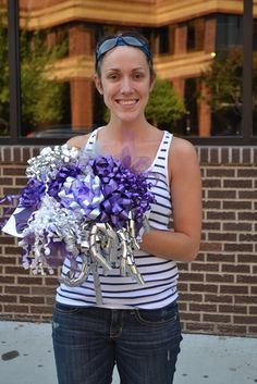 a woman holding a bouquet of purple and silver flowers