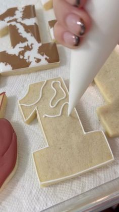 a person is decorating cookies with icing on a sheet of paper and glue