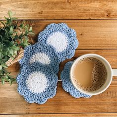 three crocheted coasters and a cup of coffee on a wooden table top