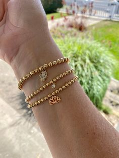 14K gold filled beaded stretch bracelets with 18K gold filled charms- classic and minimalist. Perfect for stacking and layering. Comfortable and light weight to wear. They are rust and tarnish resistant. Made with 14K gold filled beads in 3, 4 and 5mm. You can wear these as a single or add and create your stack. Each can be worn casually or dressed up. Choose your bead size 3, 4 and 5 mm and either choose to leave it plain or from one of three beautiful and elegant charms. Charm choices include: 4mm 18K gold micro pave cubic zirconia (cz) circle pendant, 18K gold filled lotus pendant and 18K gold filled CZ micro pave Hamsa evil eye charm. All bracelets are lead free, nickel free and hypoallergenic.  All bracelets are made to order and available in four sizes:  6 inches 6.5 inches 7 inches Minimalist Gold Stretch Bracelet, Hypoallergenic, Minimalist Hypoallergenic Gold Stretch Bracelet, Gold Minimalist Stretch Bracelet With Tiny Beads, Minimalist Gold Stretch Bracelet With Tiny Beads, 14k Gold Filled Spiritual Bracelets For Everyday, 14k Gold Filled Spiritual Bracelet For Everyday, Dainty 14k Gold Filled Stretch Bracelet For Everyday, Dainty Stackable Yellow Gold Stretch Bracelet, Dainty Yellow Gold Stretch Bracelet For Everyday