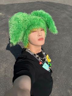 a person wearing a green furry hat