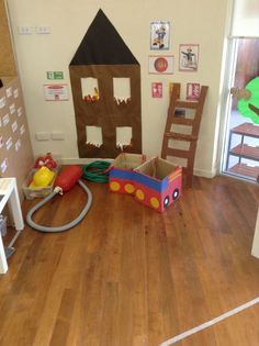 a room with wooden floors and toys on the floor, including a firetruck