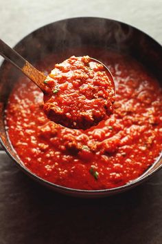 a spoon full of red sauce on top of a table