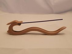 a small wooden object with a long stick sticking out of it's back end