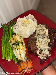 a red plate topped with meat and veggies next to mashed potatoes, asparagus