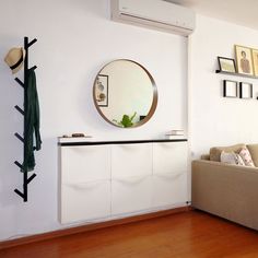 a living room filled with furniture and a round mirror hanging on the wall above it