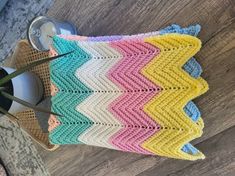 a crocheted pot holder with scissors on top of it next to a can