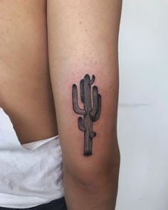 a woman's arm with a tattoo that has a cactus on the back of it