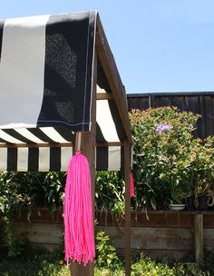 a black and white awning with pink tassels