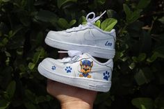 Say hello to our Paw Patrol Toddler Boy Air Force 1 Low Custom Kids Shoes! Featuring vibrant Paw Patrol designs hand-painted onto these AF1 sneakers, they're perfect for his everyday escapades. These kicks are as comfy as they are cool, ensuring he's ready for any adventure. Shop now and watch his style take flight! Hand/spray painted paw patrol boy design. Personalize with name (optional) Resistant clear coat (protected against cracks and scratches). Custom made-to-order sneaker. Brand new 100% authentic Nike AF1 Low with box! Free shipping within the US territory! Need a different color? Let us know which color you're looking for and we'll find it for you. Have an idea for your custom painted sneakers? Please send us a message here. We'll get back to you within 48hrs! Custom Baby Shoes, Paw Patrol Shoes, Personalized Sneakers, Angelus Paint, Painted Sneakers, Shoes Diy, Custom Air Force 1, Low Shoes