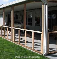 an enclosed patio with wooden railings and sliding glass doors on the side of it