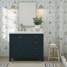 a bathroom with geometric wallpaper and blue cabinetry, along with a white rug on the floor