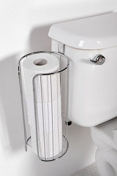 a white toilet sitting next to a trash can and paper towel dispenser