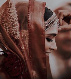 a woman in a sari getting ready to go on her wedding day with the bride's hair and makeup done