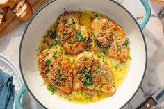 some chicken is cooking in a skillet on the counter next to slices of bread