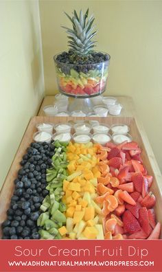 an assortment of fruit is displayed on a table with the words sour cream fruit dip