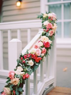 the flowers are arranged on the bannister rail