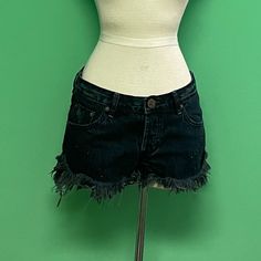 These Denim Shorts Are Ideal For Casual Wear, Including Beach Days, Festivals, Or Everyday Summer Outfits. -80% Cotton, 20% Recycled Cotton -Machine Wash -Button Fly. 5-Pocket Design -Embellished With Reflective Black Studs -Frayed, Raw-Cut Hem -Blue-Black Wash With Intentionally Distressed Detail -Waist To Shortest Hem Measures Approx 8.5" And To Longest Hem Approx 13" In Length Dark Wash Mid-rise Cotton Jean Shorts, Mid-rise Dark Wash Cotton Jean Shorts, Mid-rise Dark Wash Jean Shorts, Edgy Dark Wash Cutoff Jean Shorts, Edgy Dark Wash Shorts With Frayed Hem, Grunge Mid-rise Denim Jean Shorts, Edgy Dark Wash Cotton Shorts, Dark Wash Denim Grunge Jean Shorts, Grunge Dark Wash Denim Jean Shorts