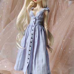 a doll with long blonde hair wearing a blue dress