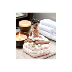 a small figurine sitting on top of a table next to towels and candles