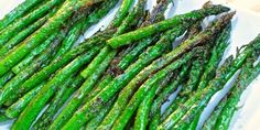 green asparagus on a white plate ready to be cooked in the oven for dinner