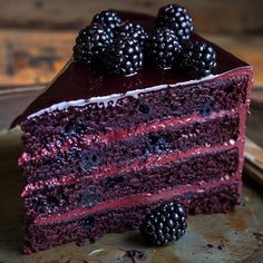 a slice of red velvet cake with blackberries on top