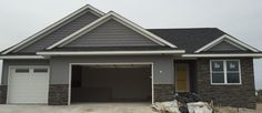 a gray house with two garages in the front