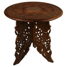 an ornate wooden table with carvings on the top and bottom, against a white background