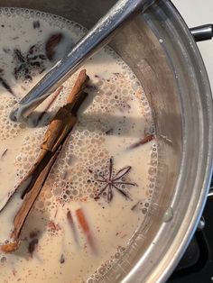 a pot filled with liquid and cinnamon sticks