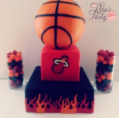 a birthday cake made to look like a basketball ball and fire balls are on top of it