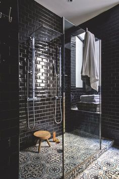 a bathroom with black tiles and green accents on the walls is featured in this article