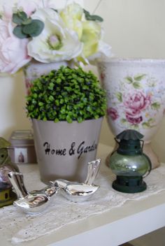 there is a potted plant on the table next to other vases and items