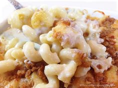 macaroni and cheese casserole on a white plate with a silver fork