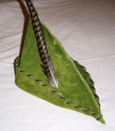 an origami style green triangle shaped object on a bed